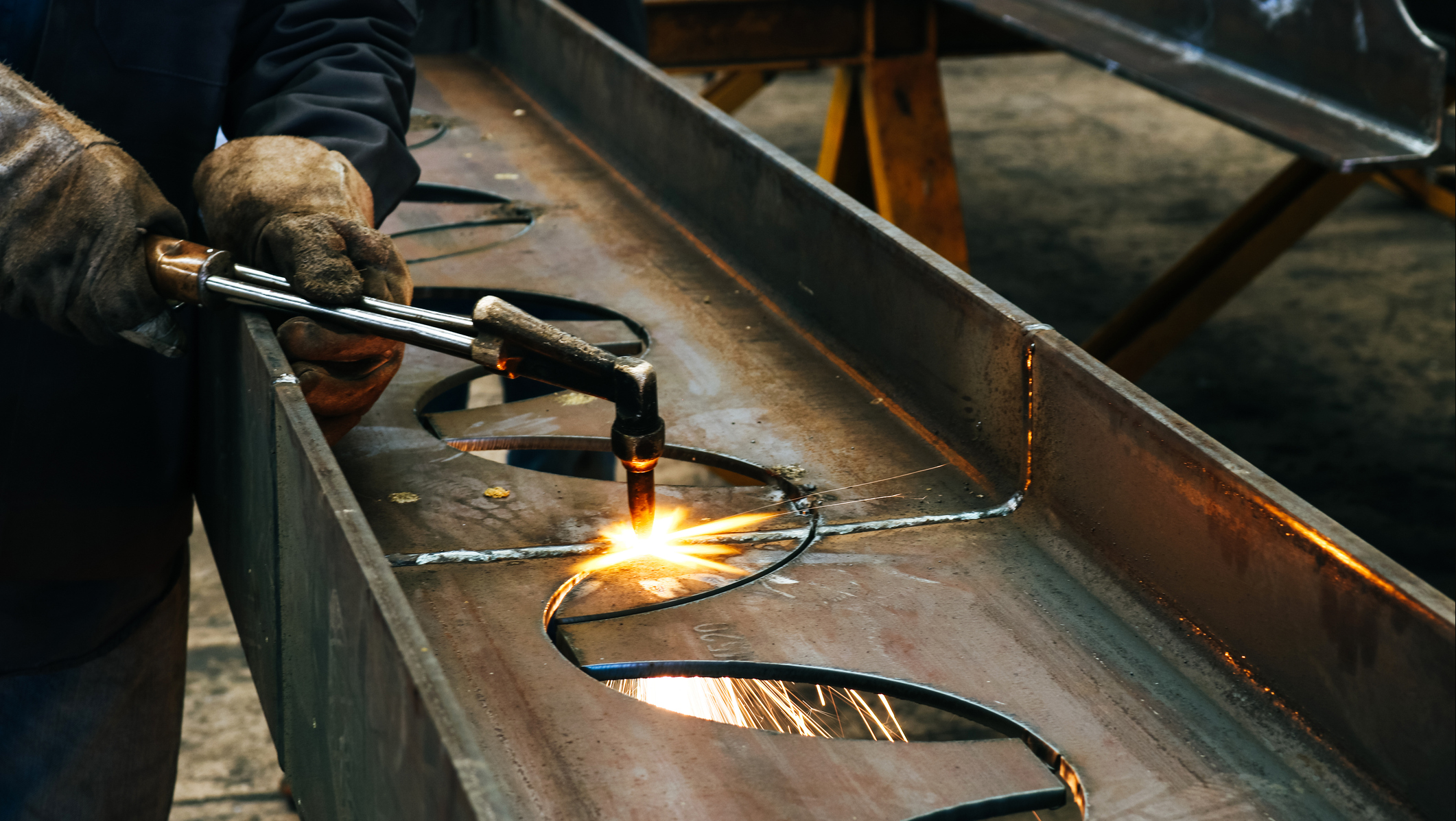 Worker cutting metal with a blowtorch.