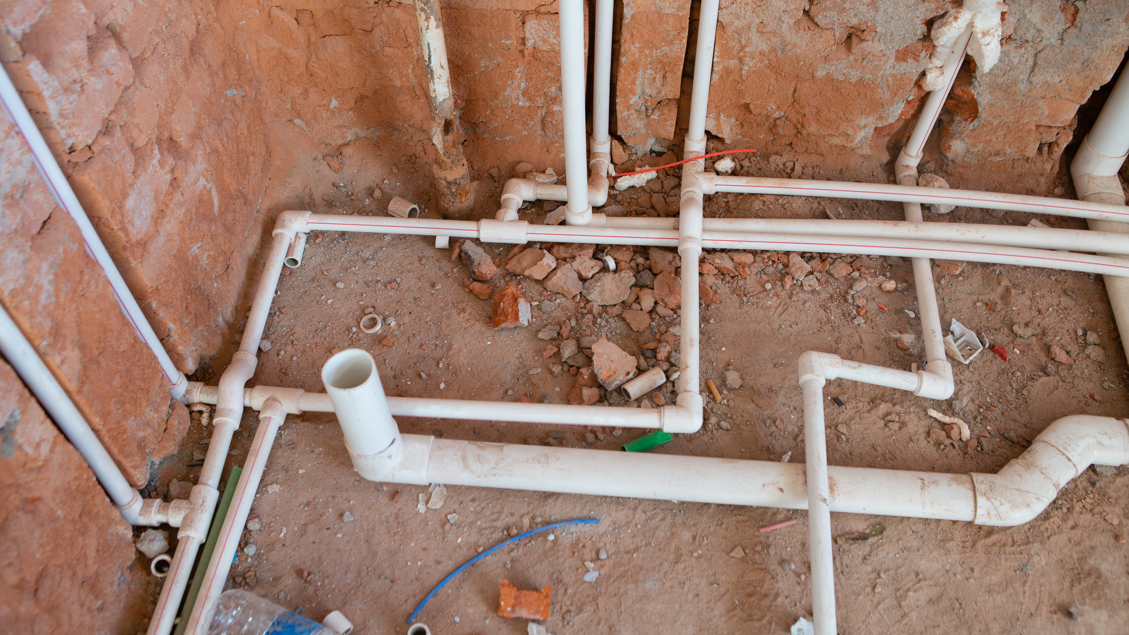 Pipes laid in construction site foundation.